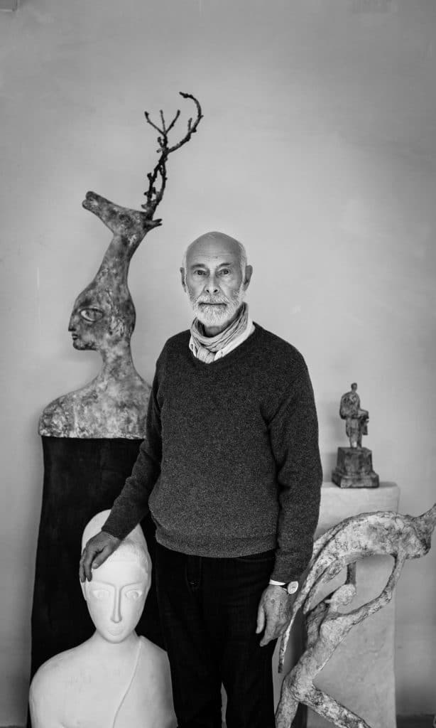 Portrait of Jean Bilquin posing with his sculptures.